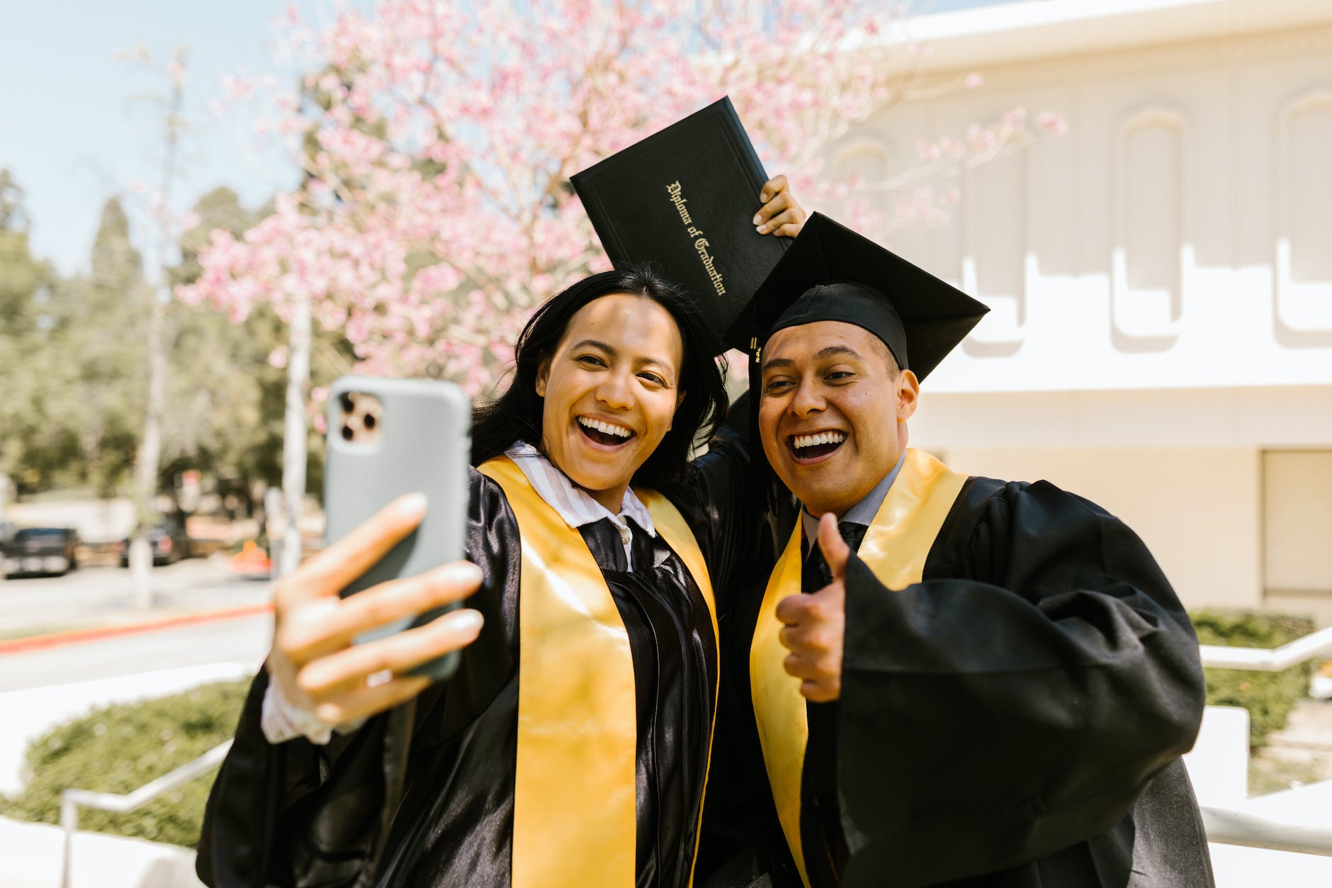 woman holding diploma taking selfie with a man